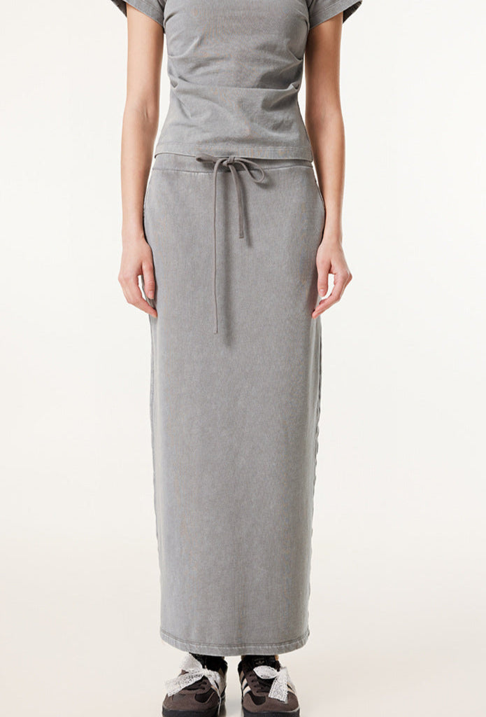 Light gray long denim skirt and matching short-sleeve top with gray and black sneakers with white bow laces