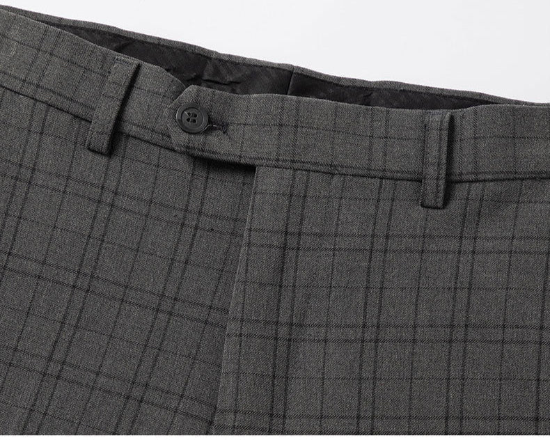 Detail of gray plaid suit trousers showing waistband construction and button closure
