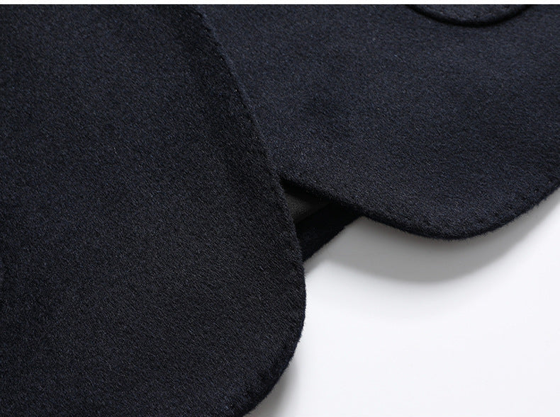 Detail of navy blazer fabric seam showing precise tailoring and quality stitching at front closure