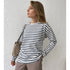 Woman wearing white and navy striped long-sleeve top with beige pants and tan shoulder bag