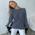 Model in navy and white striped shirt leaning back with eyes closed, seated in chair