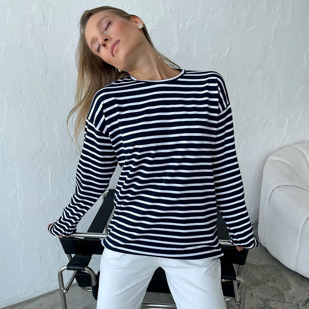 Model in navy and white striped shirt leaning back with eyes closed, seated in chair