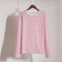 White and red striped long-sleeve shirt on wooden hanger against white wall