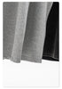 Lower hem of gray and black tank tops hanging, showing fabric texture and stitching details