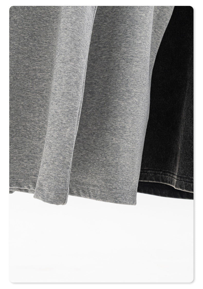 Lower hem of gray and black tank tops hanging, showing fabric texture and stitching details
