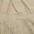 Close-up of pleated dress detail showing waistband construction and fabric gathering