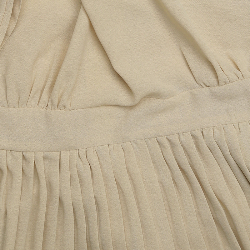 Close-up of pleated dress detail showing waistband construction and fabric gathering