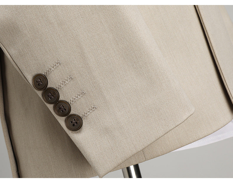 Four-button sleeve detail on beige suit jacket showing decorative stitching