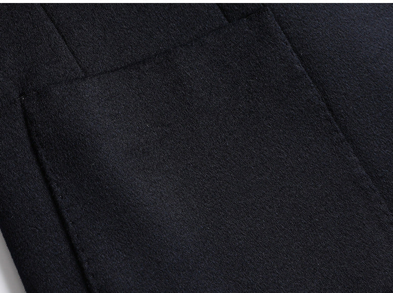 Close-up of navy blazer side pocket detail showing welt pocket construction