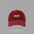Close-up of wine red Boston cotton baseball cap with white embroidered logo, premium summer beach hat