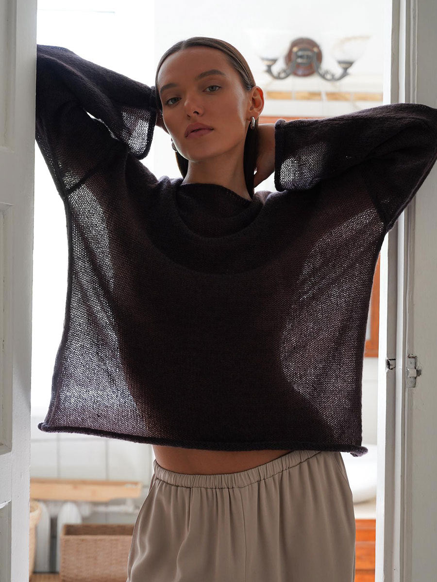Charcoal gray oversized knit sweater with gathered sleeve detail and wide neckline, styled with relaxed-fit pants