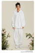 Woman wearing all-white hoodie and sweatpants set with pink headphones around neck among roses