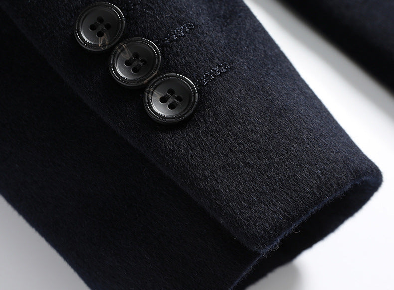 Close-up of blazer sleeve with three black buttons showing detailed cuff construction