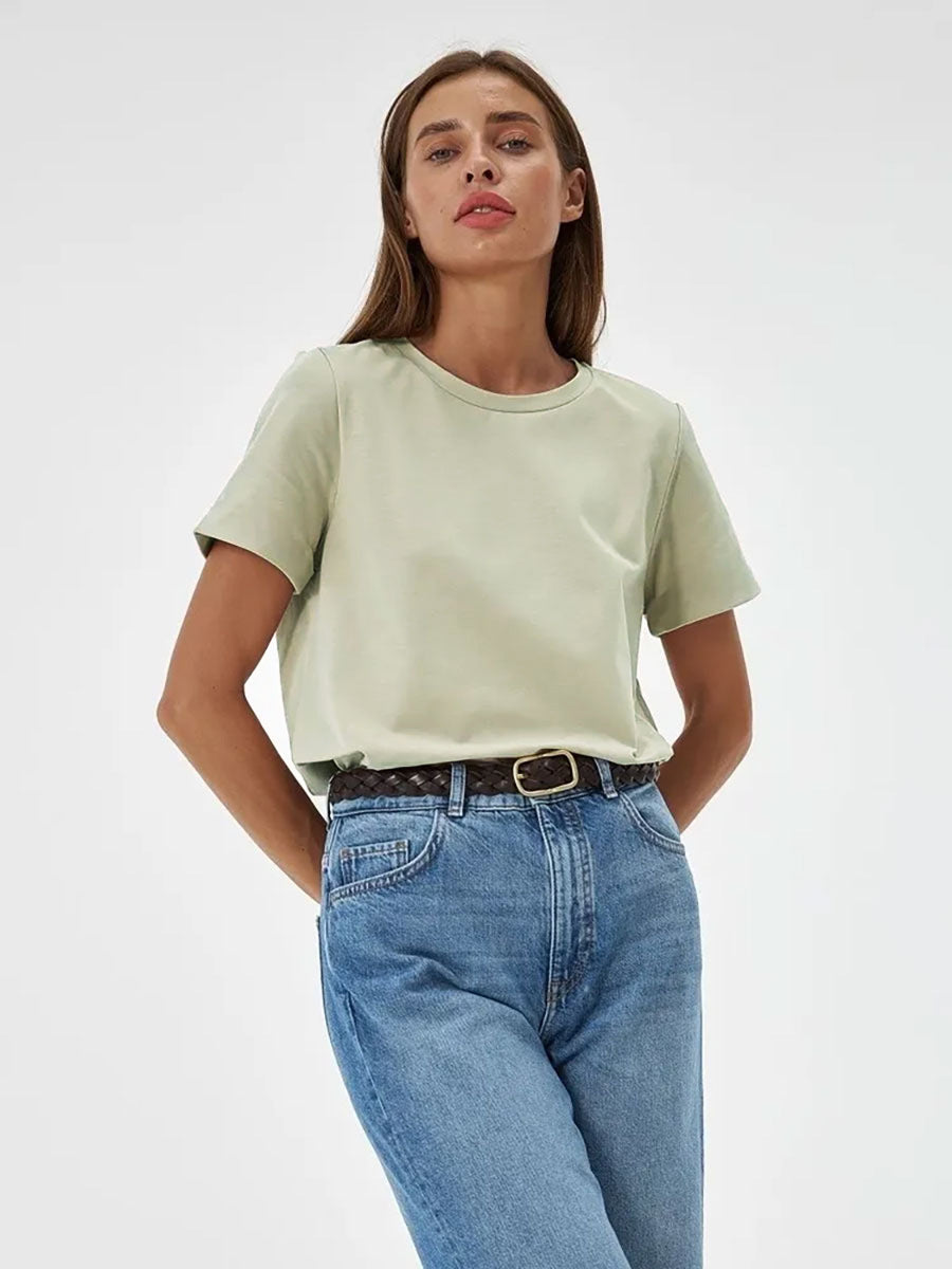 Pale Green T-Shirt Outfit – Model in a pale green T-shirt tucked into blue jeans, styled with a braided brown belt