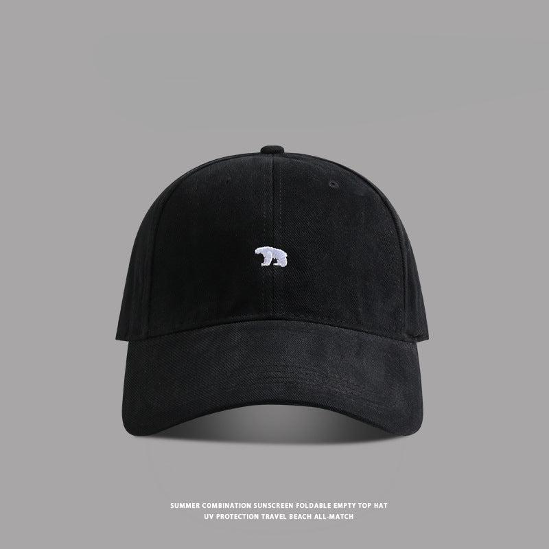 Black baseball cap with small white bear embroidery - A sleek black dad hat with a tiny white bear logo embroidered on the front