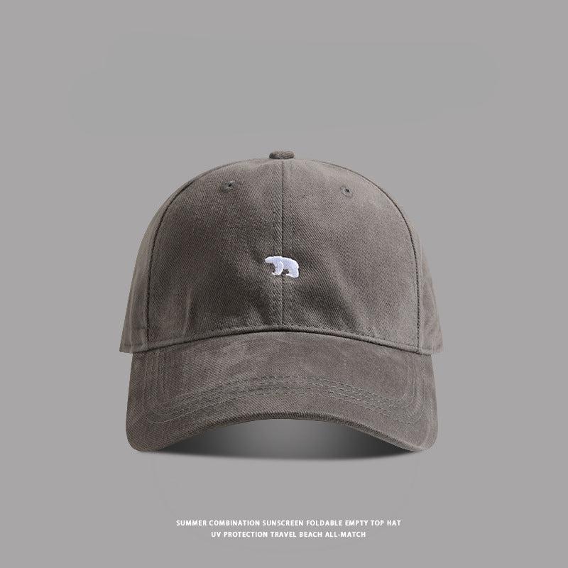 Gray baseball cap with small white bear embroidery - A deep gray dad hat with a minimalist white bear icon stitched in the front