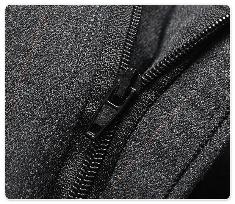 Close-up of black zipper detail on dark pinstripe wool trouser material