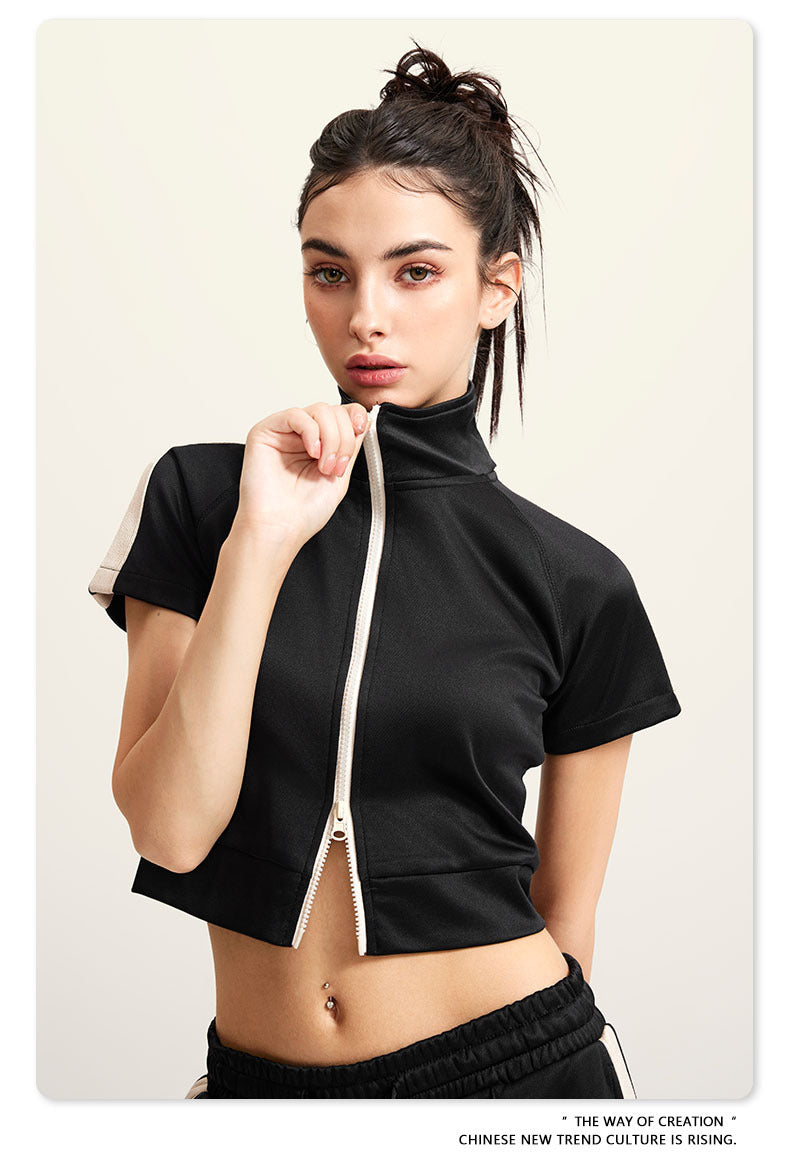Black crop top with white zip front, mock neck, short sleeves, white side stripes