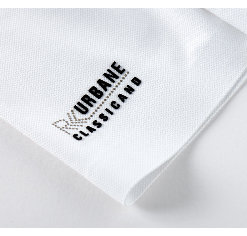 Close-up of URBANE CLASSICAND logo branding on sleeve of white polo shirt