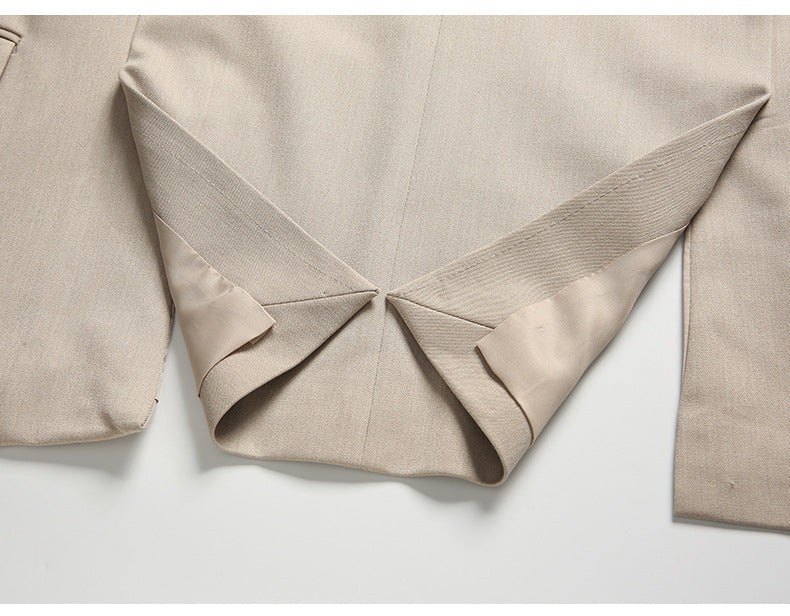 Center vent detail of beige suit jacket showing expert tailoring and drape