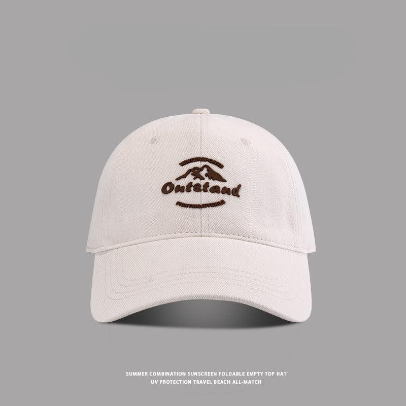 Off-white baseball cap featuring "Outstand" and a mountain logo stitched in brown