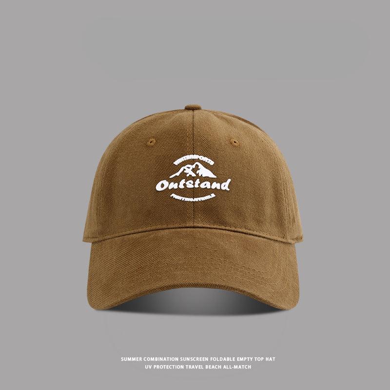Dark brown baseball cap featuring white "Outstand" and mountain logo embroidery