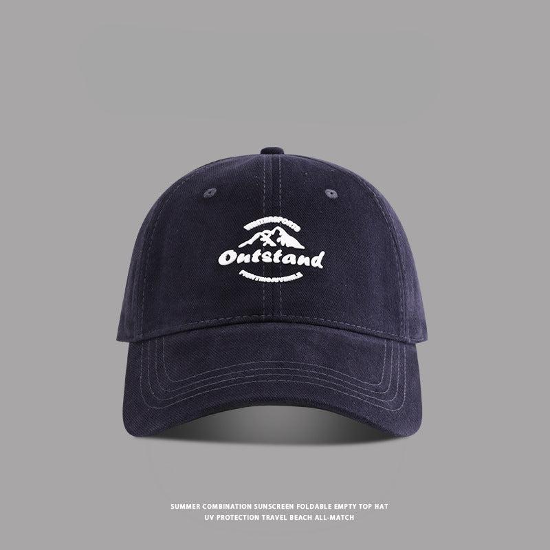 Navy blue baseball cap featuring "Outstand" embroidered in white