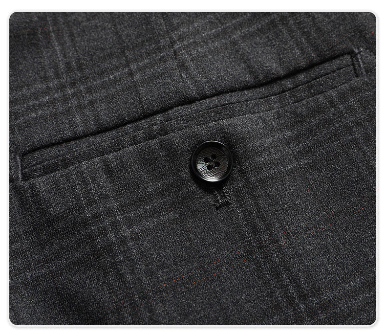 Detail of back pocket with button closure on charcoal plaid dress pants