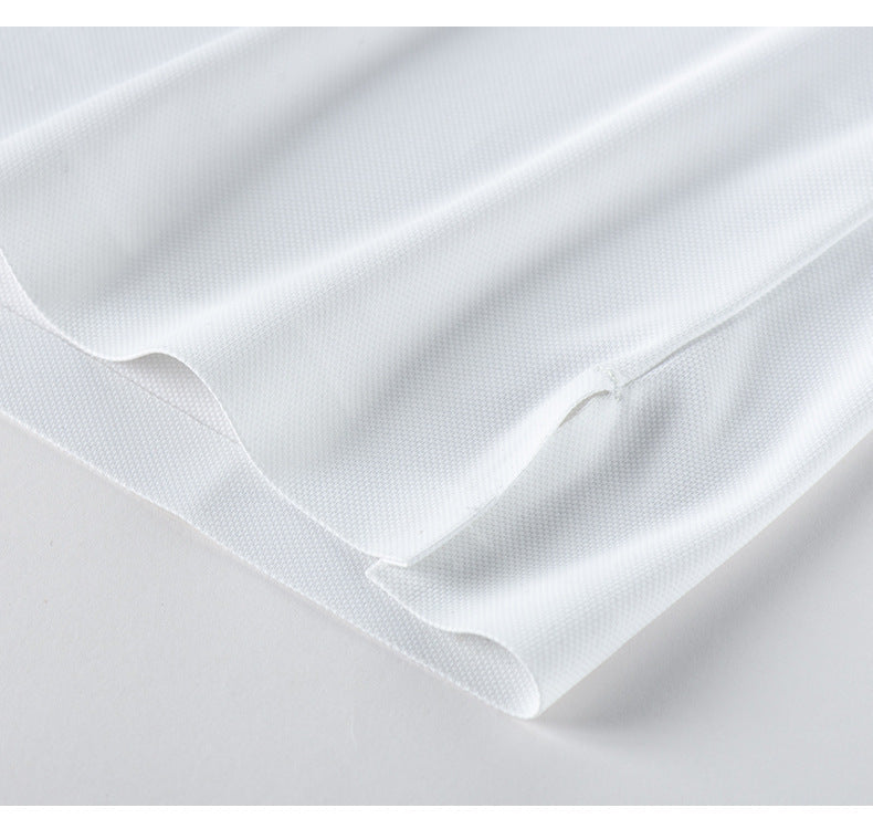 Close-up of white polo shirt fabric showing piqué texture and sleeve hem finishing