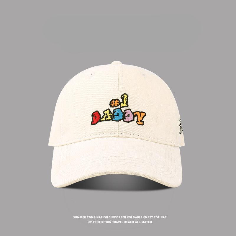 Beige baseball cap with '#1 Daddy' embroidered in colorful block letters, featuring a curved brim and adjustable strap