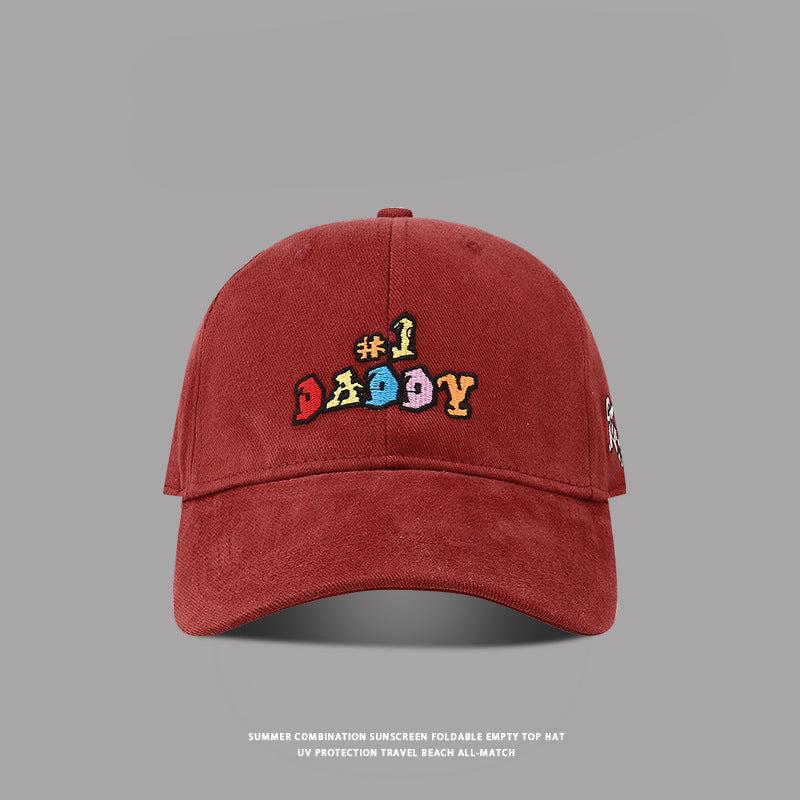 Red vintage-style baseball cap with '#1 Daddy' multicolor embroidery, curved brim, and washed fabric texture