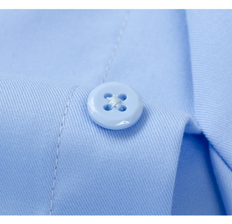 Extreme close-up of light blue dress shirt button detail showing quality four-hole button with cross-stitching on fabric