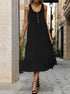 Black sleeveless midi dress with gold buttons, model standing on cobblestone street, wearing black high heels