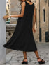 Back view of woman in black midi dress with flowing skirt, wearing low-heel black sandals