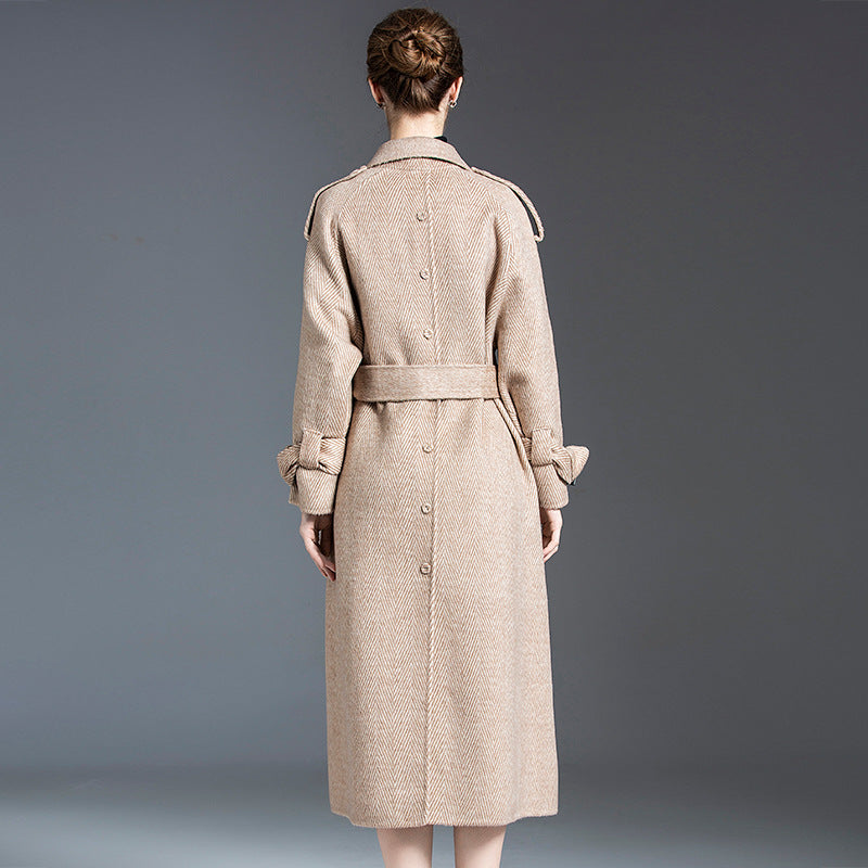 Back view of a beige wool trench coat with a belt and button details