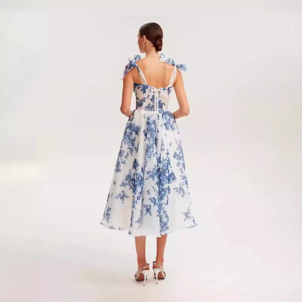 Back view of blue and white floral organza dress, highlighting delicate bow straps and fitted bodice