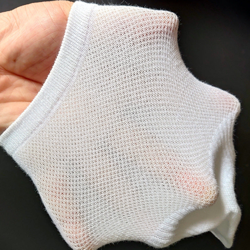 Close-up of white mesh ankle sock being held in hand showing lightweight breathable fabric construction and ribbed edge against dark background