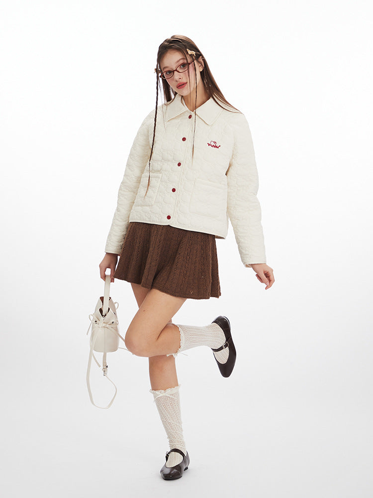 Woman wearing a white puffer jacket, brown skirt, and white shoes on a white background