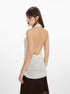 Backless view of white halter top with beaded strap and low-cut back