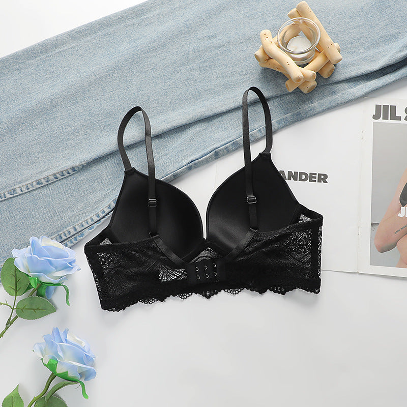 A black push-up bra with back closure and lace detailing arranged with blue roses and denim fabric. Magazine visible in corner