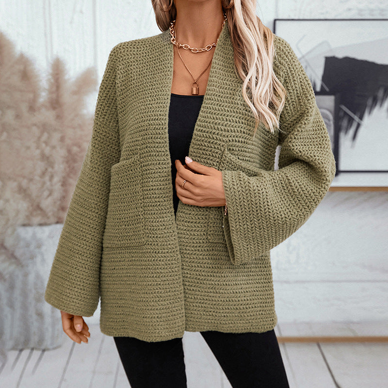 Front view of relaxed-fit green knit cardigan showing detailed herringbone stitch pattern and patch pockets