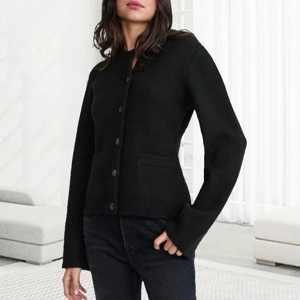 Black knit cardigan with streamlined design, model in contemporary minimalist space