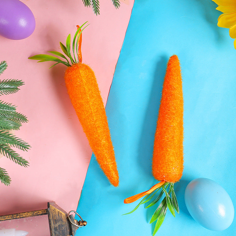 Two artificial carrots of different sizes with hanging loops, placed on a colorful pink and blue background with Easter decor.