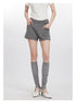 Front view of gray shorts with structured waist, worn with knee socks and vintage-style white heels