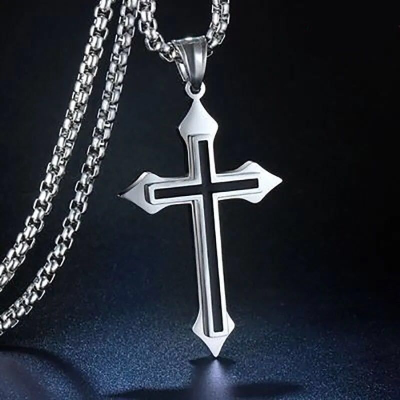 Silver stainless steel cross pendant with black inlay, displayed against a dark background