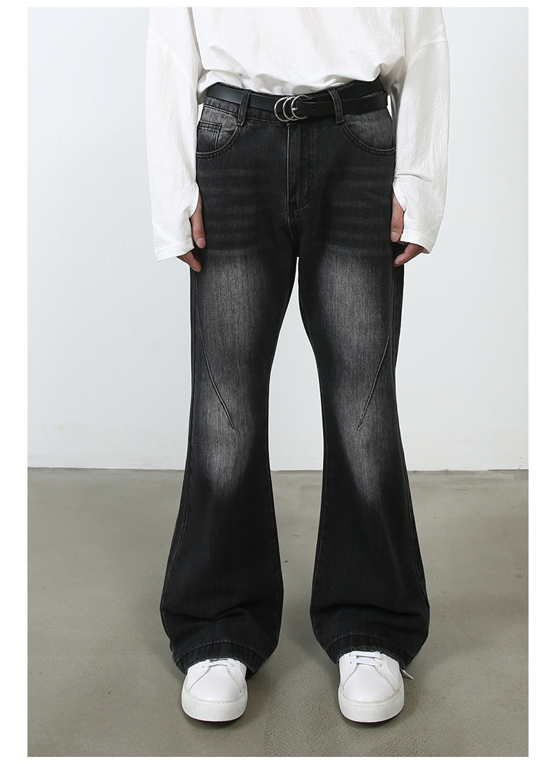 Front view of model wearing white oversized shirt, black triple-ring belt and black wide-leg jeans with diagonal seam detail