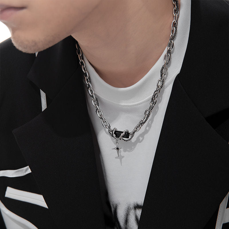 Close-up of silver chain necklace with black stone and star pendant
