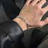 Close-up of a stainless steel zigzag bracelet on wrist, paired with a leather jacket for a bold fashion statement.