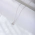 A silver Star of David pendant necklace with crystal accents displayed on white fabric. The minimalist six-pointed star pendant hangs on a fine chain
