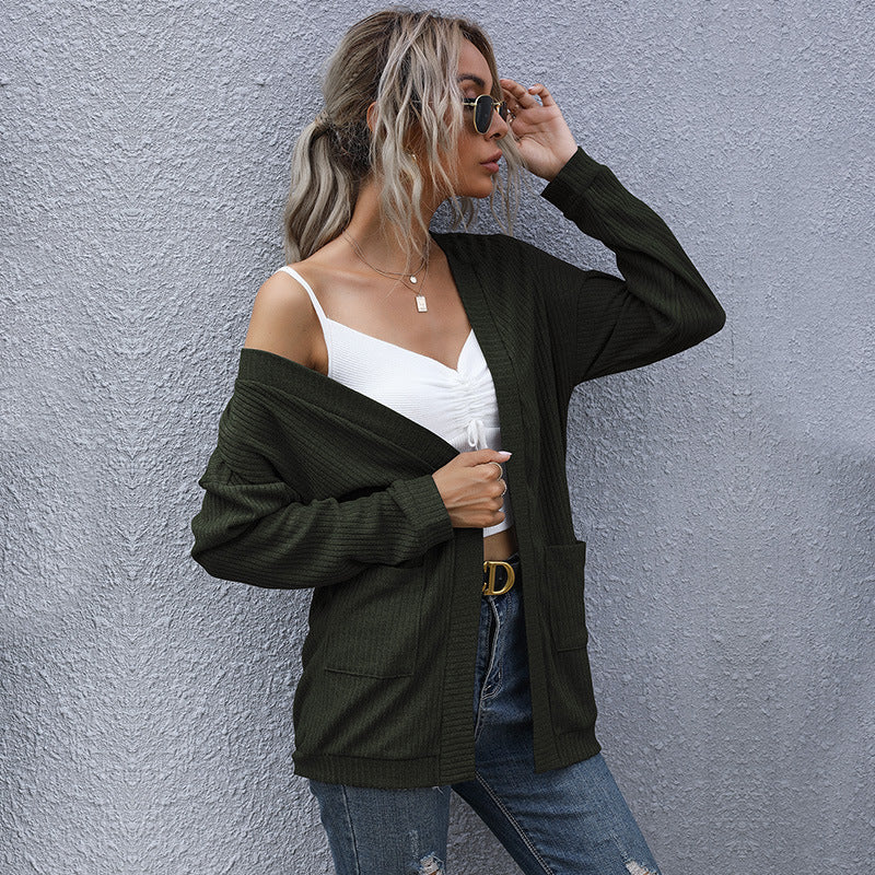 Casual outfit with army green cardigan, white crop top, and distressed denim